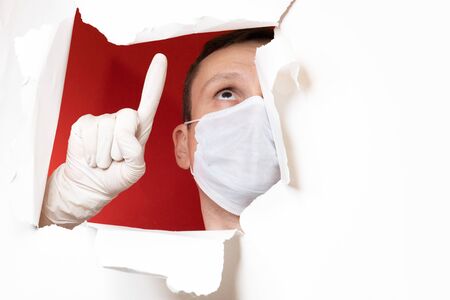 Coronavirus. Business man, wears a protective mask. A business man in a coronavirus quarantine wears a protective mask. Work at home. Cleans hands with disinfectant gel. No virus.の写真素材