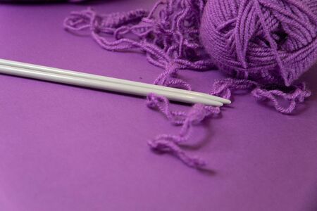 Background with knitting tools and accesories, colorful purple skein yarn, hobby concept, copyspaceの写真素材