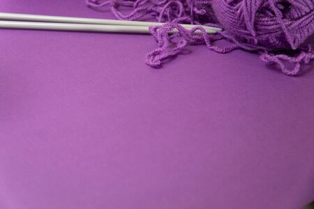 Background with knitting tools and accesories, colorful purple skein yarn, hobby concept, copyspaceの写真素材