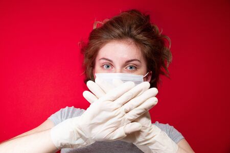 Stop the virus and epidemic diseases. Healthy woman in blue medical protective mask showing gesture stop. Health protection and prevention during flu and infectious outbreakの写真素材