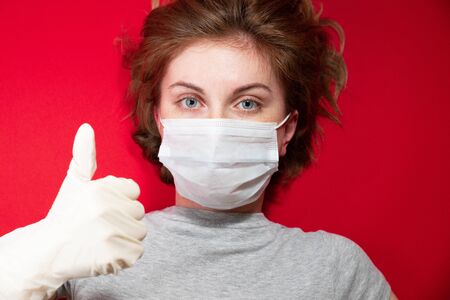 Stop the virus and epidemic diseases. Healthy woman in blue medical protective mask showing gesture stop. Health protection and prevention during flu and infectious outbreakの写真素材