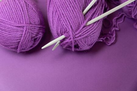 Background with knitting tools and accesories, colorful purple skein yarn, hobby concept, copyspaceの写真素材