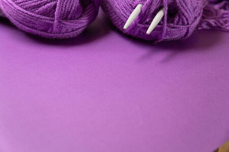 Background with knitting tools and accesories, colorful purple skein yarn, hobby concept, copyspaceの写真素材