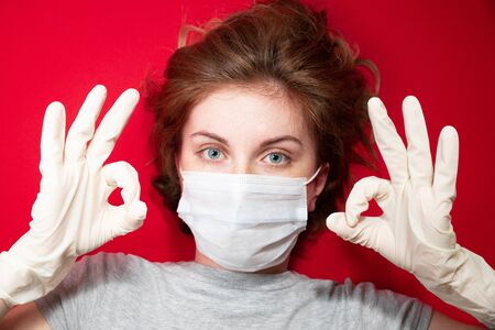 Stop the virus and epidemic diseases. Healthy woman in blue medical protective mask showing gesture stop. Health protection and prevention during flu and infectious outbreakの写真素材