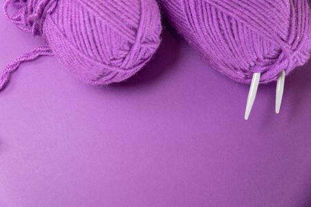 Background with knitting tools and accesories, colorful purple skein yarn, hobby concept, copyspace