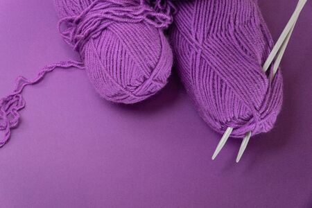 Background with knitting tools and accesories, colorful purple skein yarn, hobby concept, copyspaceの写真素材