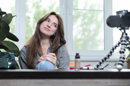 Young beautiful european woman professional beauty vlogger or blogger write up tutorial to share on social networks. Online makeup training. Beauty concept.の写真素材