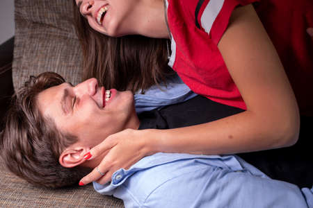 Close-up of a young romantic couple kissing and enjoying each others company at home. The concept of romance and familyの写真素材