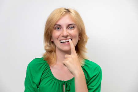 Portrait of a beautiful woman with braces on her teeth, isolated on a white background. The concept of the perfect smileの写真素材