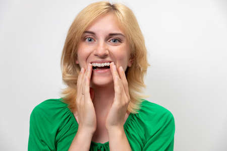 Portrait of a beautiful woman with braces on her teeth, isolated on a white background. The concept of the perfect smileの写真素材