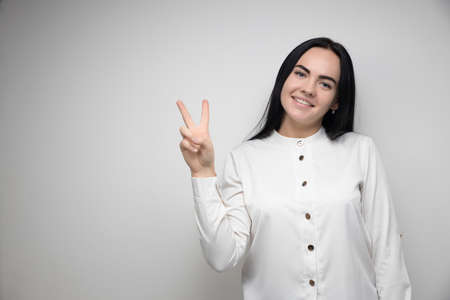 Happy pretty young woman with long brown hair, smiling and making hand gestures, dressed in casual clothes. Im loving it. Good job.The concept of human emotions. Copy spaces for your textの写真素材