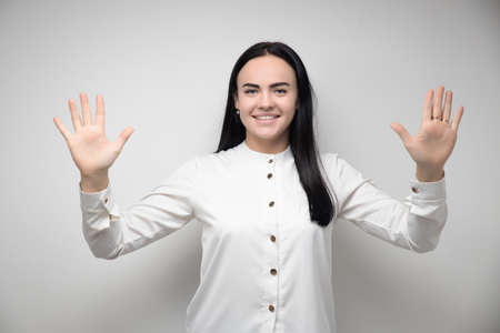 Happy pretty young woman with long brown hair, smiling and making hand gestures, dressed in casual clothes. Im loving it. Good job.The concept of human emotions. Copy spaces for your textの写真素材