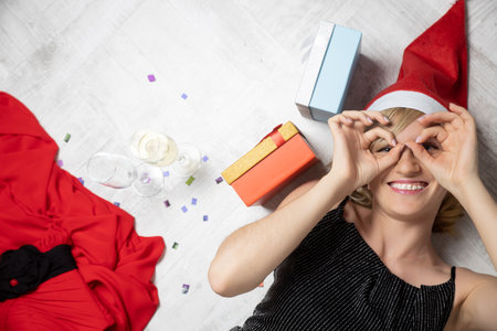 Beautiful happy woman having fun lying on the floor. The concept of celebration of birthday or New yearの写真素材