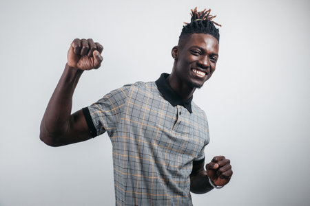 Portrait of excited cheerful handsome delightful joyous guy raising his hands up, isolated on greyの写真素材