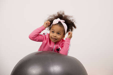 Happy African-American girl, African baby girl isolated on white background. an emotional, cheerful little girl with an excited expression, laughing and looking upの写真素材