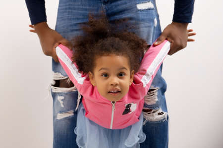 Black dad lifting daughter up having fun outdoor loving father little kid play funny game spend summer day feels happy enjoy time together, family leisure activities, relative people love care conceptの写真素材