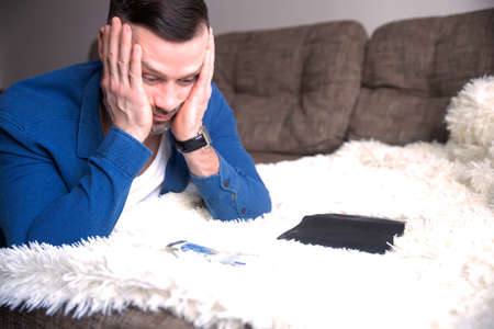 Frustrated young guy with last money have no savings to payment bill, loan. Bankruptcy, bankrupt and financial debtの写真素材
