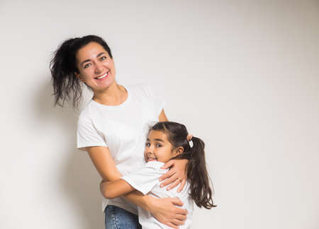 Happy woman mother cuddling tender cute little girl daughter with closed eyes, two woman generationsの写真素材