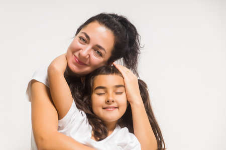 Happy woman mother cuddling tender cute little girl daughter with closed eyes, two woman generationsの写真素材