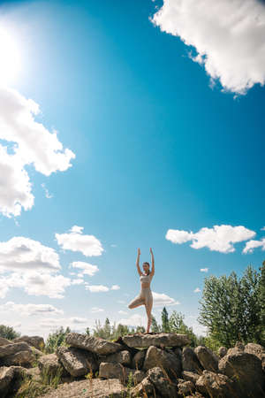 Young girl doing yoga outdoor. Young woman practicing yoga in bamboo house, nature on background.Female happiness.Caucasian woman practicing yoga on vacation on Bali islandの写真素材