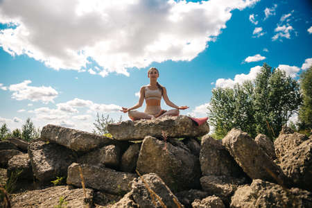 Lifestyle woman yoga exercise and pose for healthy life. Young girl or people pose balance body vital zen meditation for workout nature mountain background in morning sunrise with mat outdoor banner.の写真素材