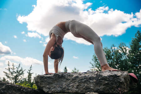 Yoga. Young woman practicing yoga or dancing or stretching in nature at park. Health lifestyle concept.の写真素材