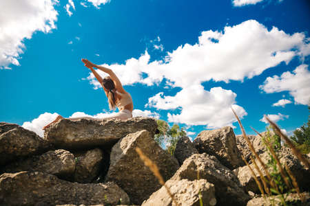 Yoga. Young woman practicing yoga or dancing or stretching in nature at park. Health lifestyle concept.の写真素材