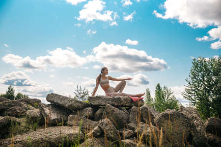 Yoga. Young woman practicing yoga or dancing or stretching in nature at park. Health lifestyle concept.の写真素材
