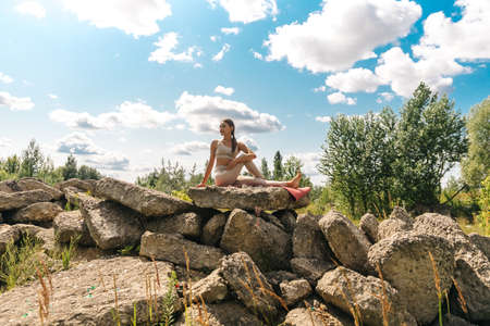 Yoga. Young woman practicing yoga or dancing or stretching in nature at park. Health lifestyle concept.の写真素材