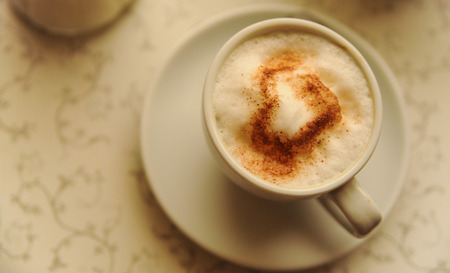 cup of cappuccino with heart on the tableの写真素材