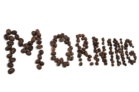 morning word spelled out of coffee beans on white backgroundの写真素材
