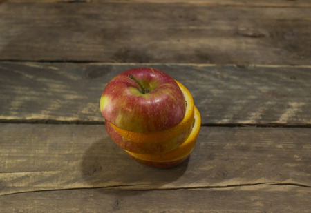 Fresh ripe apple and orange on a wooden table .の写真素材
