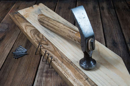 Hammer and nails on wooden background