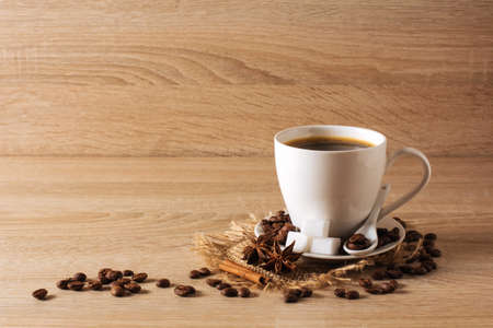 white cup of coffee, coffee beans, cinnamon, anise, backgroundの写真素材