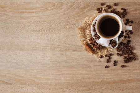white cup of coffee, coffee beans, cinnamon, anise, background, view from aboveの写真素材