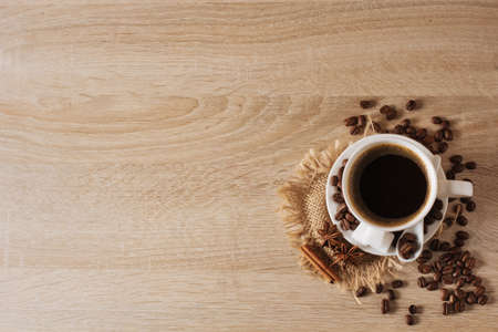 white cup of coffee, coffee beans, cinnamon, anise, background, view from aboveの写真素材
