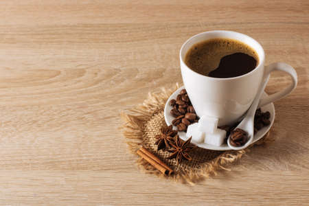 white cup of coffee, coffee beans, cinnamon, anise, backgroundの写真素材