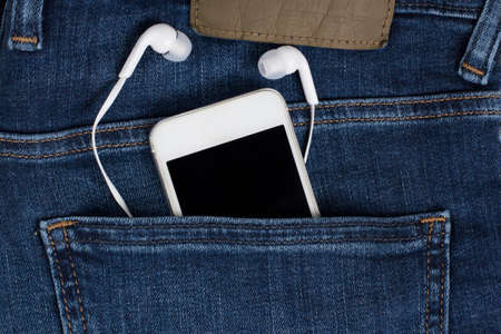 Mobile phone headphones pocket jeans fashion musicの写真素材