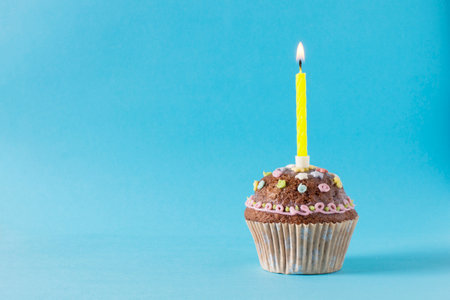 homemade muffin, cupcake with candle on a blue backgroundの写真素材