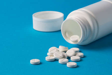 white jar for pills and vitamins on a blue backgroundの写真素材