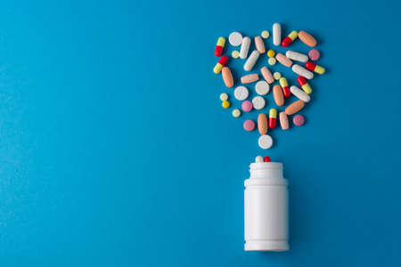 jar for pills, capsules and vitamins on a blue backgroundの写真素材