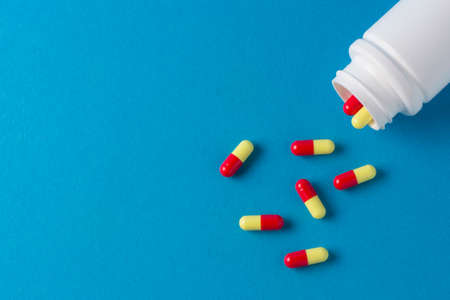 white jar for pills and capsules on a blue backgroundの写真素材