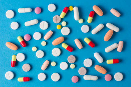 a lot of pills, vitamins, capsules on a blue backgroundの写真素材