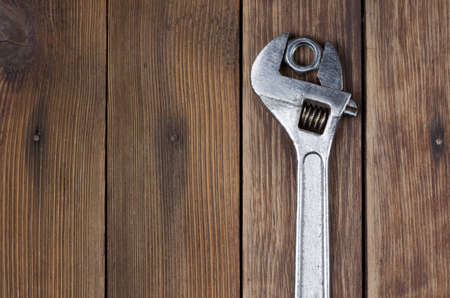 wrench and screw nut on a wooden backgroundの写真素材
