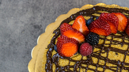 Chocolate sponge cake, strawberry, raspberry, blackberry, top view, stone table, one quarter of the progの写真素材