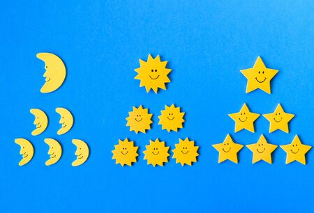 leadership concept, the icons of stars, crescents and suns in the form of pyramids lie on a blue backgroundの写真素材