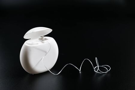 Dental floss in a white box front view, isolated on a black background