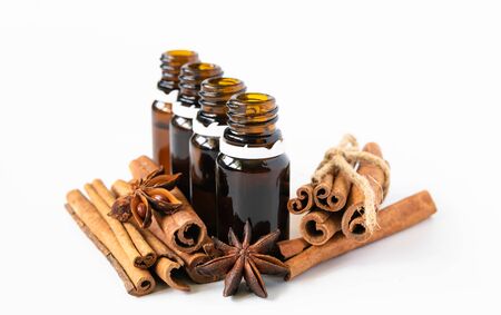 Composition with essential cinnamon oil in glass bottles on white backgroundの写真素材