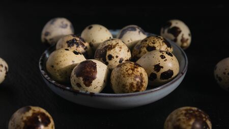 quail eggs on a plate on a dark background, close-upの写真素材