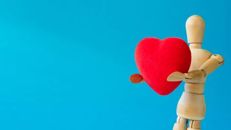Wooden figure with red heart on blue backgroundの写真素材